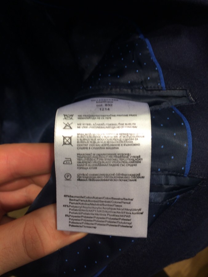 Vaatteen materiaalilapun saa pahimmillaan kaivaa esiin suljetun napin takaa